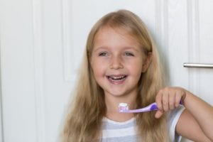 Little girl smiling with a toothbrush in her hand