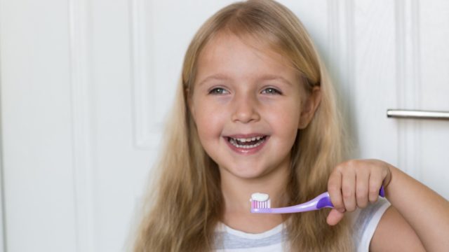 Little girl smiling with a toothbrush in her hand